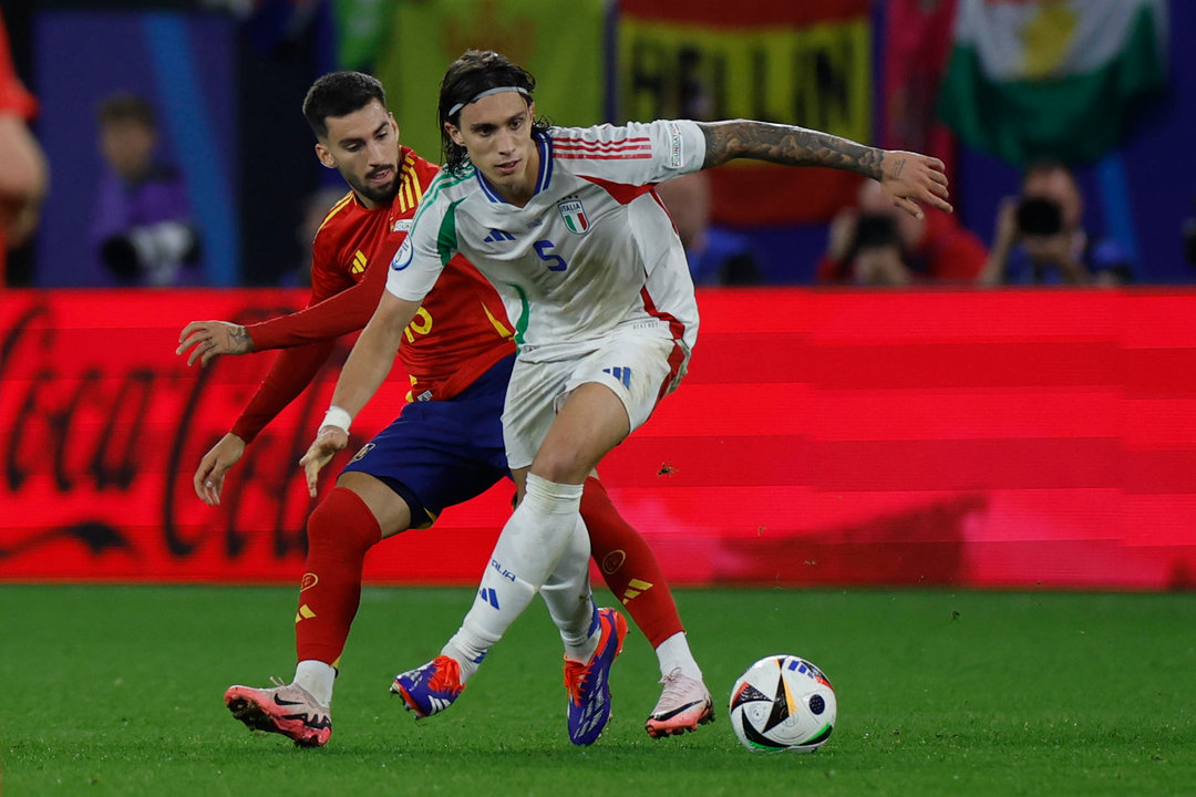 El defensa de la selección italiana, Ricardo Calafiori (d), intenta controlar el balón ante el centrocampista de la selección española, Alex Baena, durante el encuentro de la fase de grupos de la Eurocopa 2024 que España e Italia disputan hoy jueves en el Arena AufSchalke, Gelsenkirchen (Alemania). EFE/Alberto Estévez.