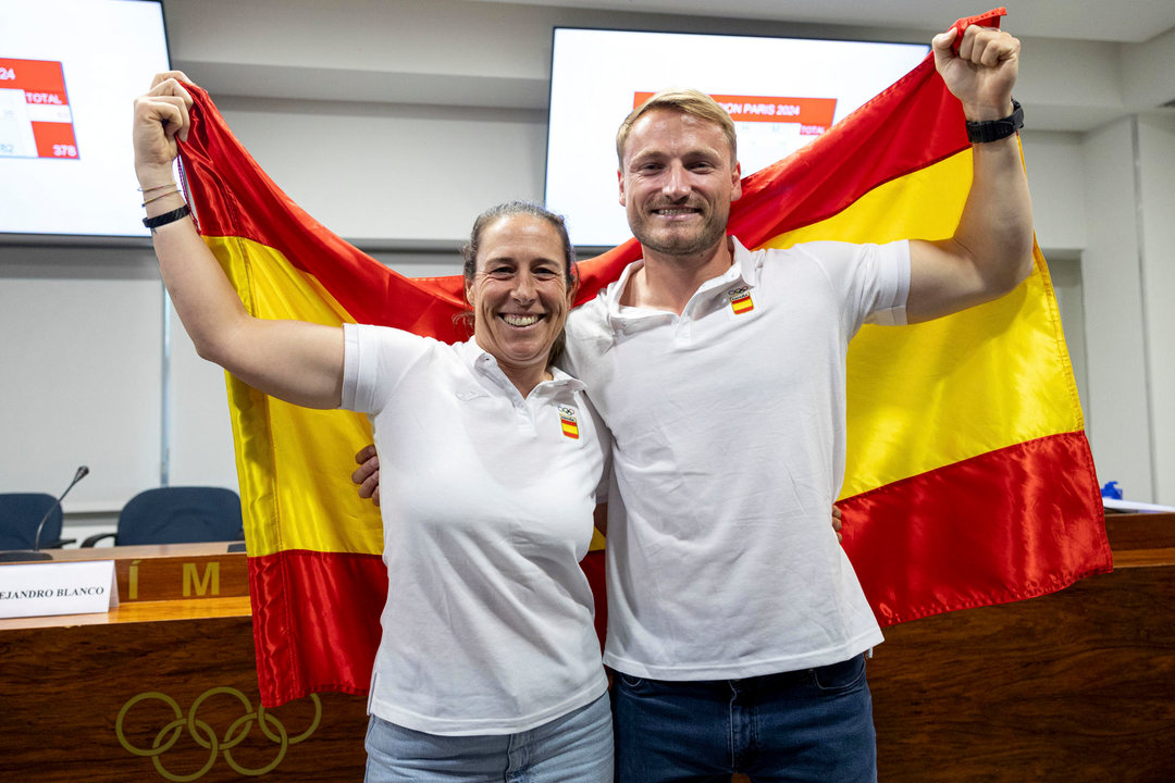 El piragüista Marcus Cooper junto a la regatista Tamara Echegoyen posan con la bandera de España tras anunciar en rueda de prensa que serán los abanderados de España en los próximos Juego Olímpicos de París. EFE/ Daniel Gonzalez