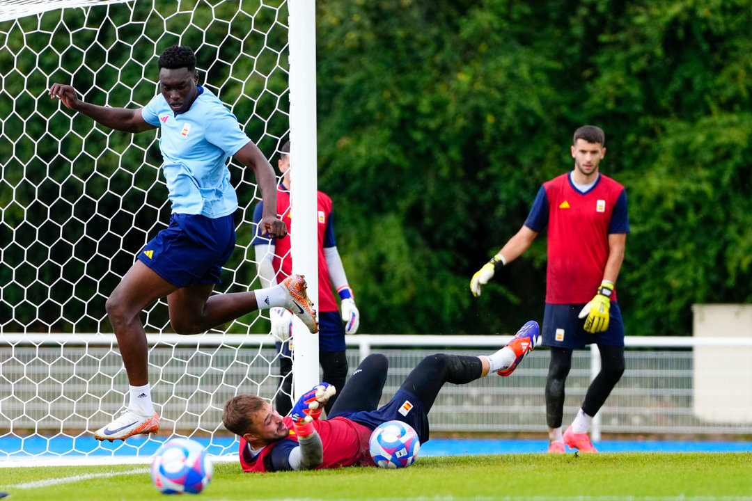 Los futbolistas de la Selección Olímpica masculina Samu Omorodion (i) y Arnau Tenas (c) participan en el entrenamiento de este martes en el Stade Louis Boury de París, Francia, en la víspera de su debut en el Torneo Olímpico de Fútbol frente a Uzbekistán en el Parque de los Príncipes. EFE/RFEF