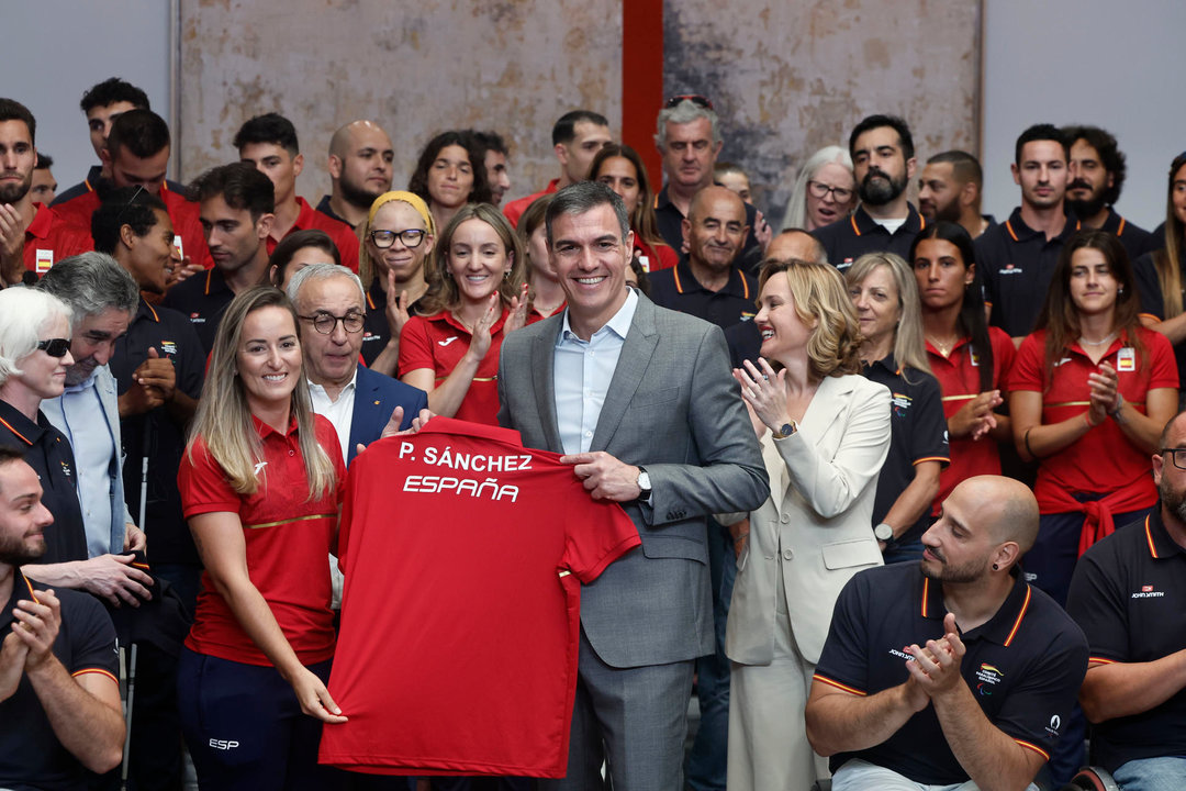 El presidente del Gobierno, Pedro Sánchez recibe una camiseta de manos de la deportista fátima Gálvez durante  la recepción a los equipos olímpico y paralímpico. EFE/ Sergio Pérez