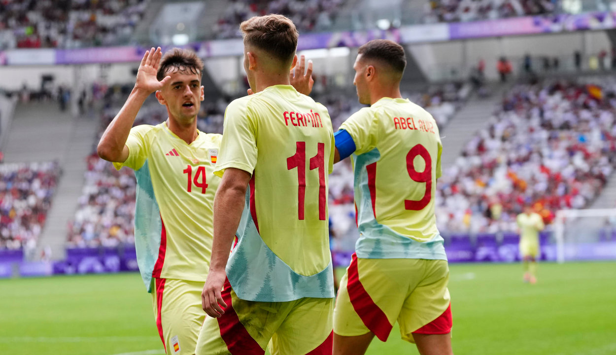 El futbolista español Fermín López (c) celebra con sus compañeros Abel Ruiz (d) y Aimar Oroz (i) tras marcarle un gol a la República Dominicana durante el partido del Grupo C de fútbol masculino de los Juegos Olímpicos de París 2024 disputado en el Estadio de Burdeos. EFE/ M. Reino