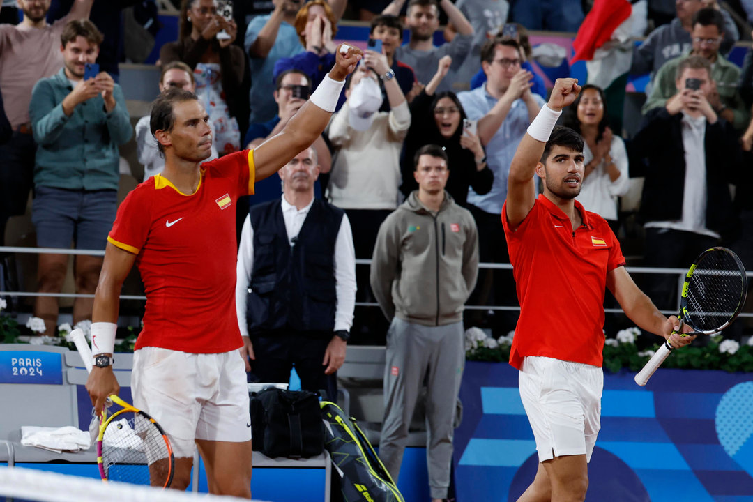 Los tenistas españoles Rafael Nadal (i) y Carlos Alcaraz celebran la victoria en el partido de dobles frente a los argentinos Máximo González y Andrés Molteni, correspondiente a la primera ronda de dobles masculino de tenis de los Juegos Olímpicos de París 2024 en la pista Phillipe Chatrier de París. EFE/ Juanjo Martín