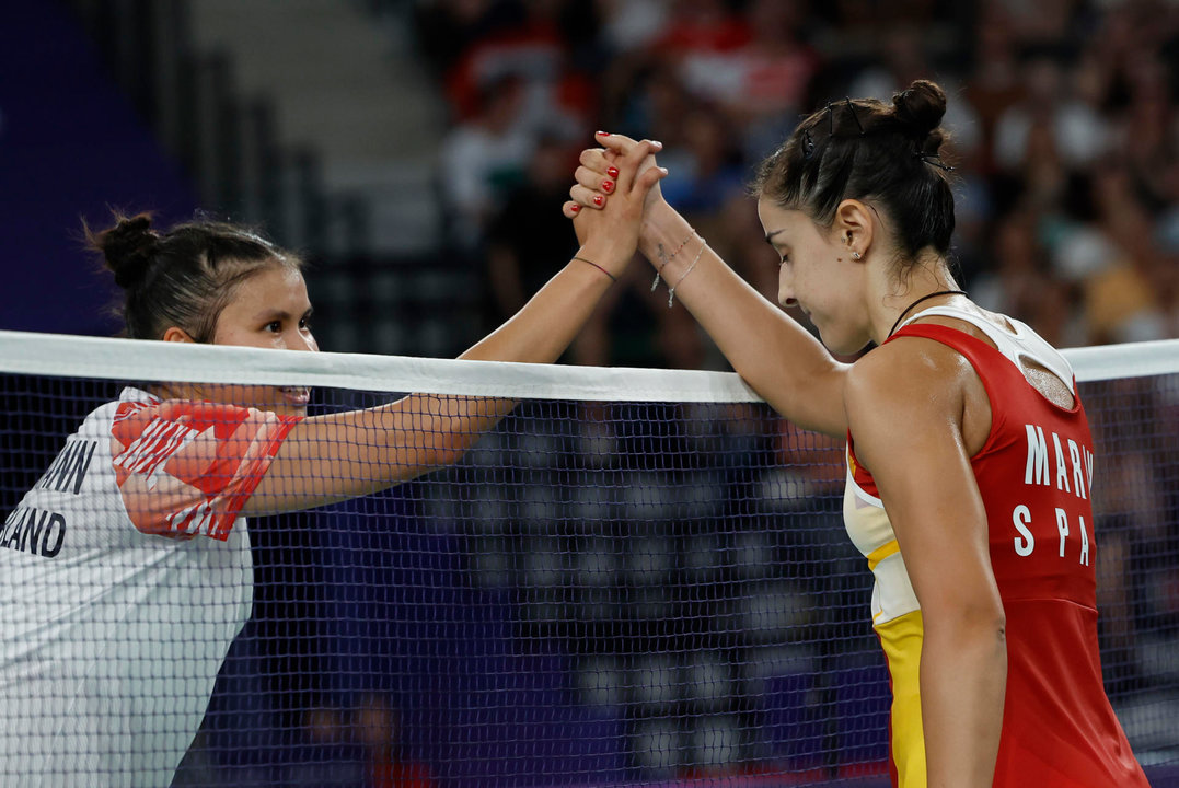 La jugadora de bádminton española Carolina Marín estrecha la mano a la suiza Jenjira Stadelmann (i) tras ganar su partido de la fase de grupos de la competición de bádminton femenino individual de los Juegos Olímpicos de París 2024 este domingo en el pabellón Arena Porte de Chapelle en París, Francia. Marín ha ganado por 21-11 y 21-19. EFE/ Julio Muñoz