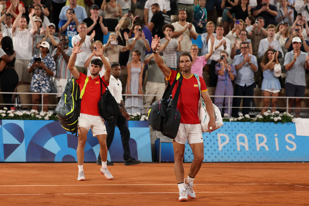 Los tenistas españoles Rafa Nadal (d) y Carlos Alcaraz saludan tras perder ante los estadounidenses Austin Krajicek y Rajee Ram en los cuartos de final de dobles masculinos de tenis de los Juegos Olímpicos de París 2024, en el complejo de tenis Roland Garros de París. EFE/ Juanjo Martín