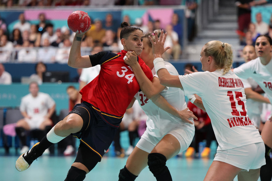 La jugadora española Alicia Fernández ante las húngaras Noemi Pasztor (c) y Kinga Debreczeni-Klivinyi (d) durante el partido de balonmano femenino del grupo B de los Juegos Olímpicos de París 2024 este jueves en París. EFE/ Miguel Gutiérrez