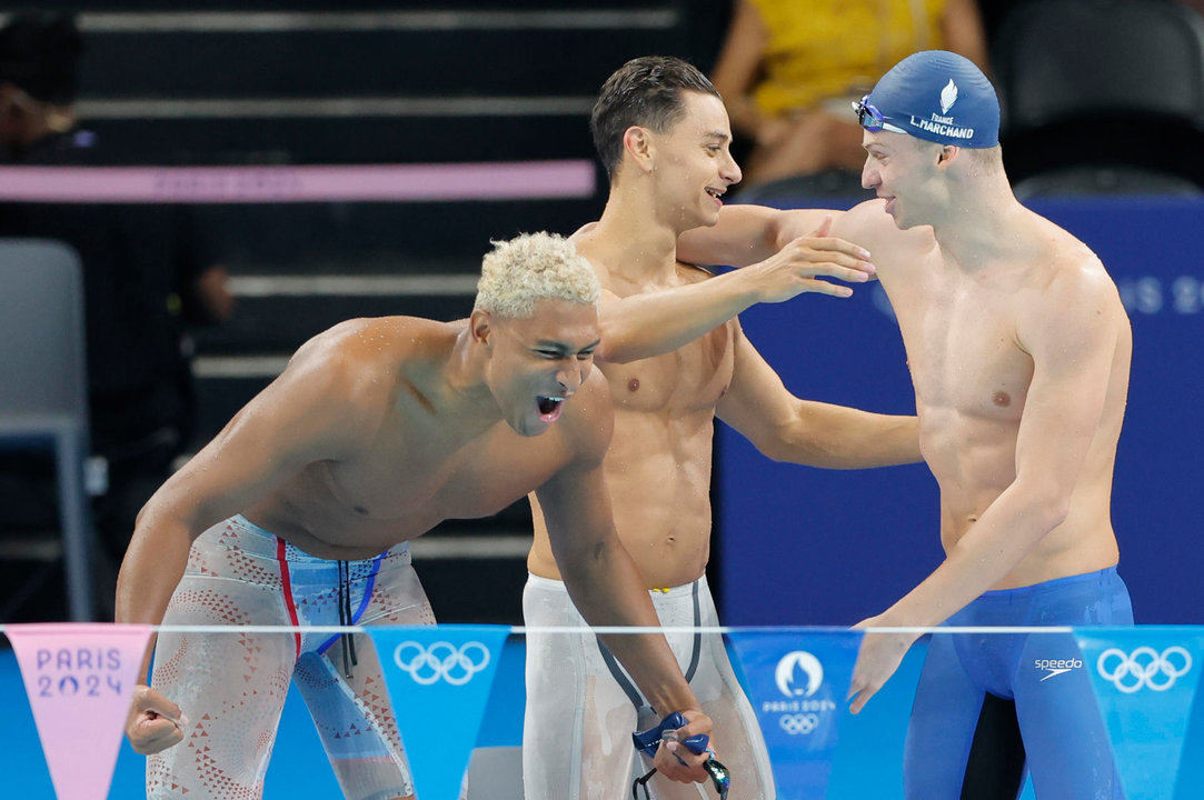 El equipo galo de relevos 4x100m estilos masculino con Leon Marchand (d) Clement Secchi (c) y Yohann Ndoye-Brouard celebra tras acabar primeros en su serie de los Juegos Olímpicos de París 2024 este sábado en Nanterre. EFE/Lavandeira Jr.