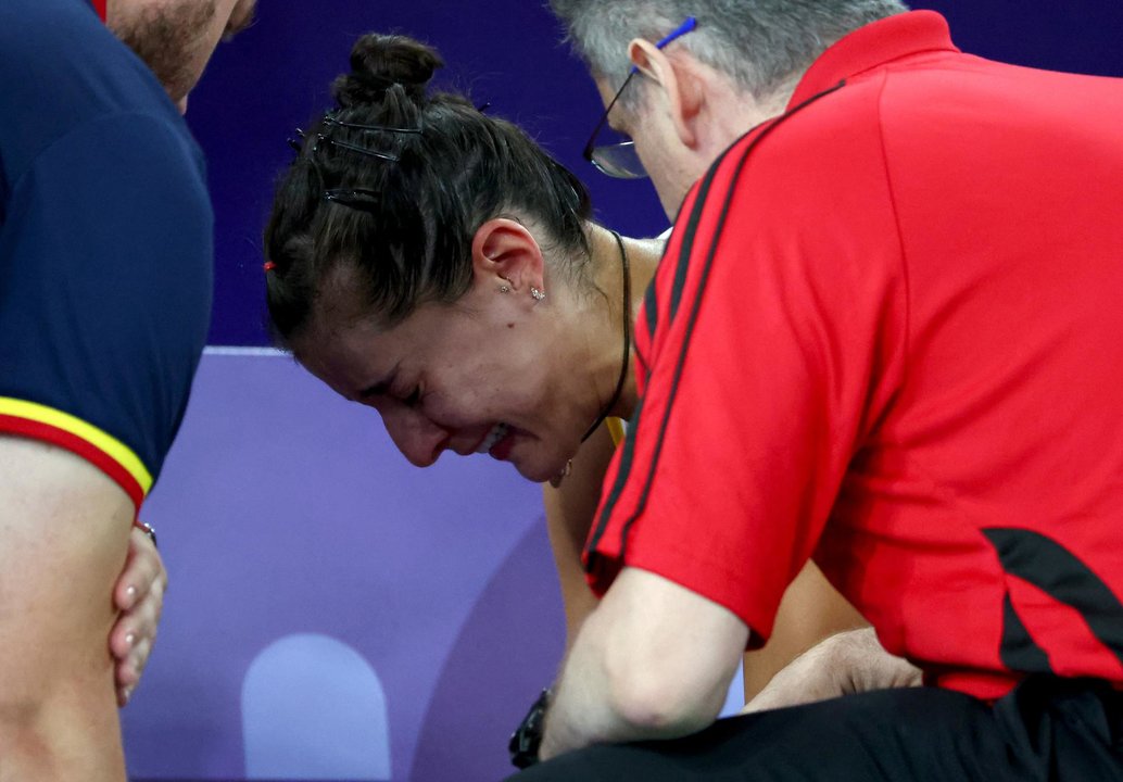 Carolina Marin, desconsolada tras comprobar que no puede continuar disputando la semifinal olímpica de bádminton ante He Bing Jiao, de China, al lesionarse en la rodilla derecha. EFE/EPA/DIVYAKANT SOLANKI