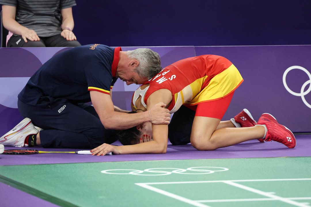 Carolina Marín llora junto a su entrenador, Fernando Rivas, tras verse obligada a retirarse, lesionada, su partido de semifinales del bádminton olímpico de París 2024. EFE/ Miguel Gutiérrez