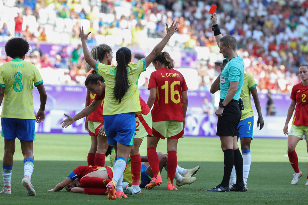 El árbitro Espen Nor (d) saca tarjeta roja a la delantera brasileña Marta tras la falta realizada a la defensa española Olga Carmona, en el partido del Grupo C del torneo olímpico de fútbol, disputado en el Estadio de Burdeos (Francia). EFE/ Kiko Huesca