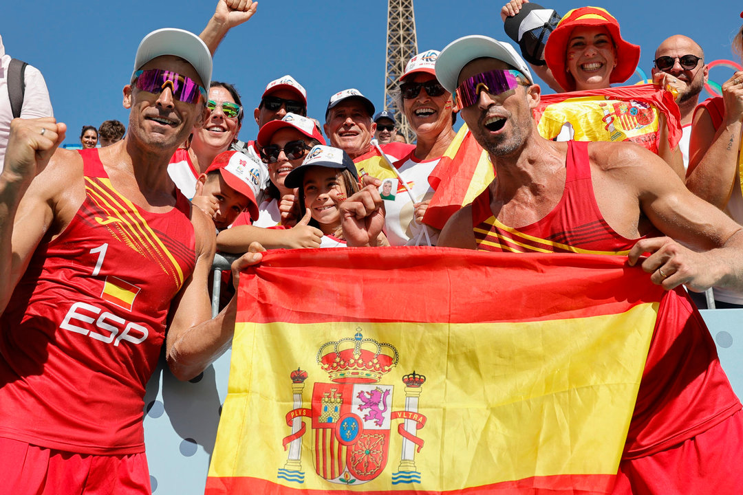 Los españoles Pablo Herrera (i) y Adrián Gavira (d) celebran su victoria al finalizar el partido de octavos de final del torneo olímpico voley playa masculino contra los polacos Michal Bryl y Bartosz Losiak. EFE/Lavandeira Jr