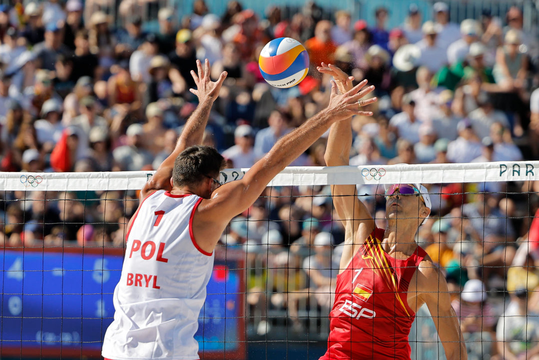 El español Pablo Herrera (d) durante el partido de octavos de final del torneo olímpico de voley playa masculino contra los polacos Michal Bryl (i, de espaldas) y Bartosz Losiak. EFE/Lavandeira Jr