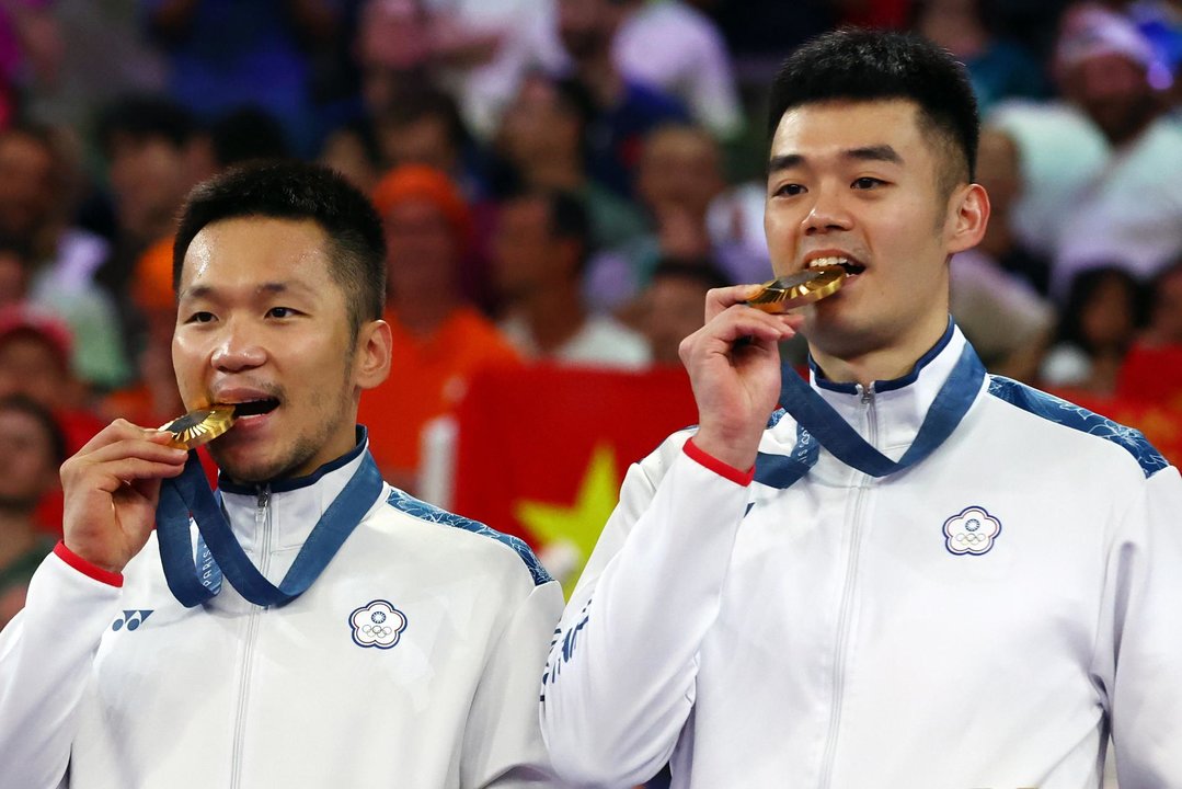 La dupla taiwanesa formada por Lee Yang y Wang Chi-lin celebran su oro tras imponerse a China en la final de dobles masculina de bádminton. EFE/EPA/DIVYAKANT SOLANKI