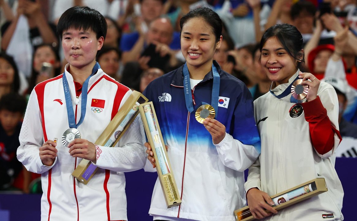 La china Bing Jiao He (iz) homenajeó a Carolina Marín posando en el podio con un pin de la delegación española en señal de cariño y apoyo. EFE/EPA/DIVYAKANT SOLANKI