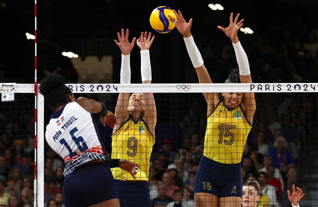 La dominicana Paola Peña (i) trata de superar el bloqueo de ls brasileñas Silva Ratzke (c) y Carolina da Silva (d) durante el partido de cuartos de final del torneo olímpico. EFE/EPA/DIVYAKANT SOLANKI