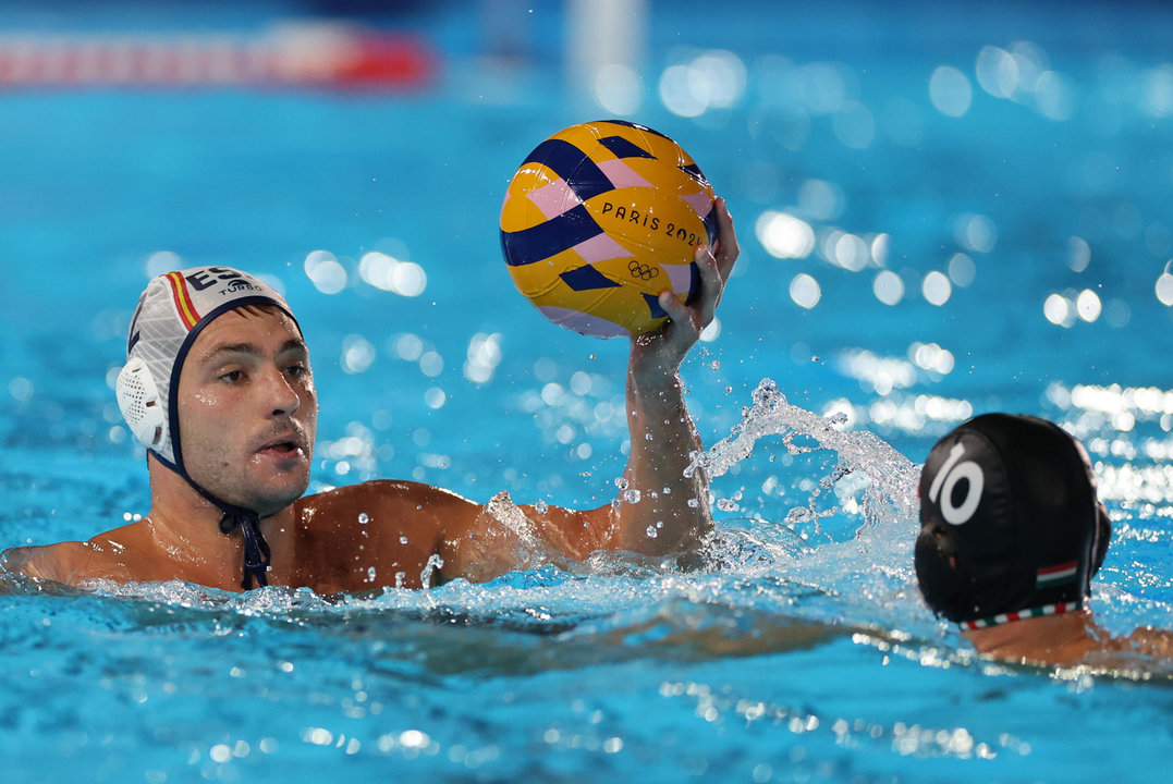 El lateral de España Alberto Munarriz (i) en acción ante el húngaro Denes Varga durante el partido de ronda preliminar del Grupo B de Waterpolo Masculino, entre España y Hungría, parte de los Juegos Olímpicos de París 2024, en Saint-Denis (Francia). EFE/ Miguel Gutiérrez