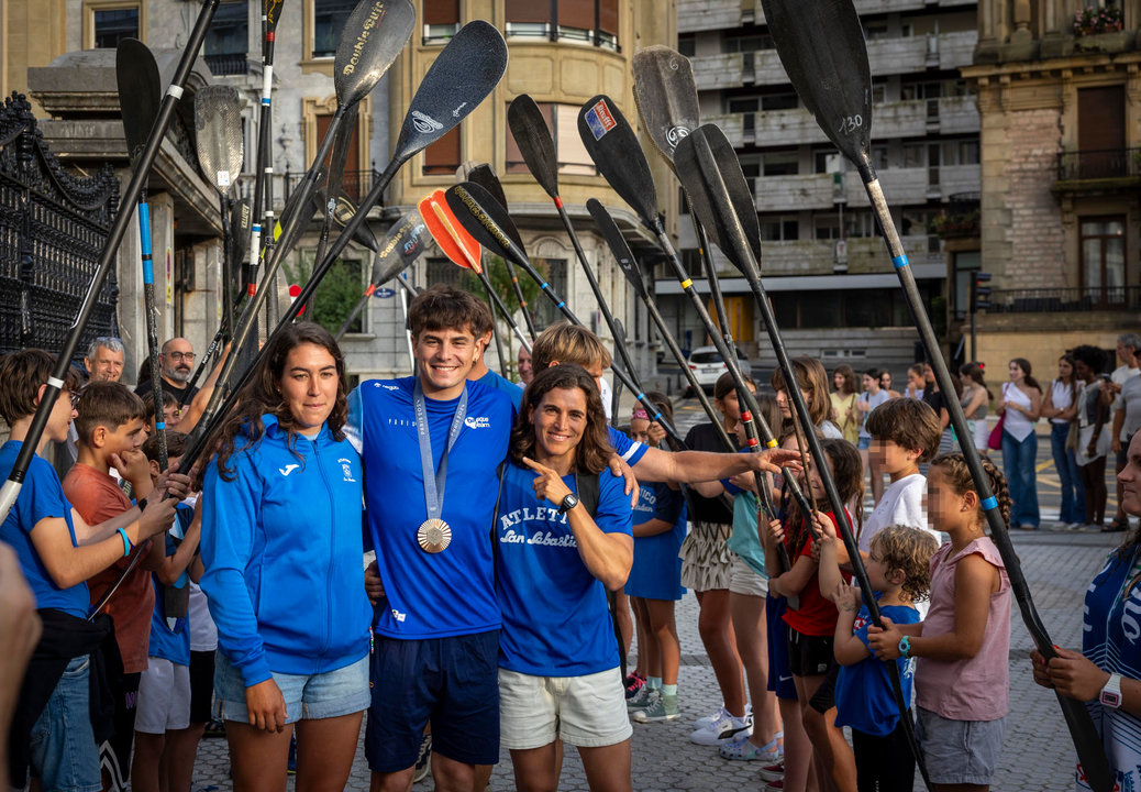 El piragïsta donostiarra Pau Etxaniz (c), que ha obtenido la medalla de bronce en la prueba de K1 de piragüismo eslalon de los Juegos de París 2024, durante un acto de bienvenida a los deportistas olímpicos del Club Atlético San Sebastián celebrado este martes, junto a la piragüistas Maialen Chourraut (d), oro en Río 2016, entre otras medallas, y Miren Lazkano (i), finalista en París. EFE/Javier Etxezarreta