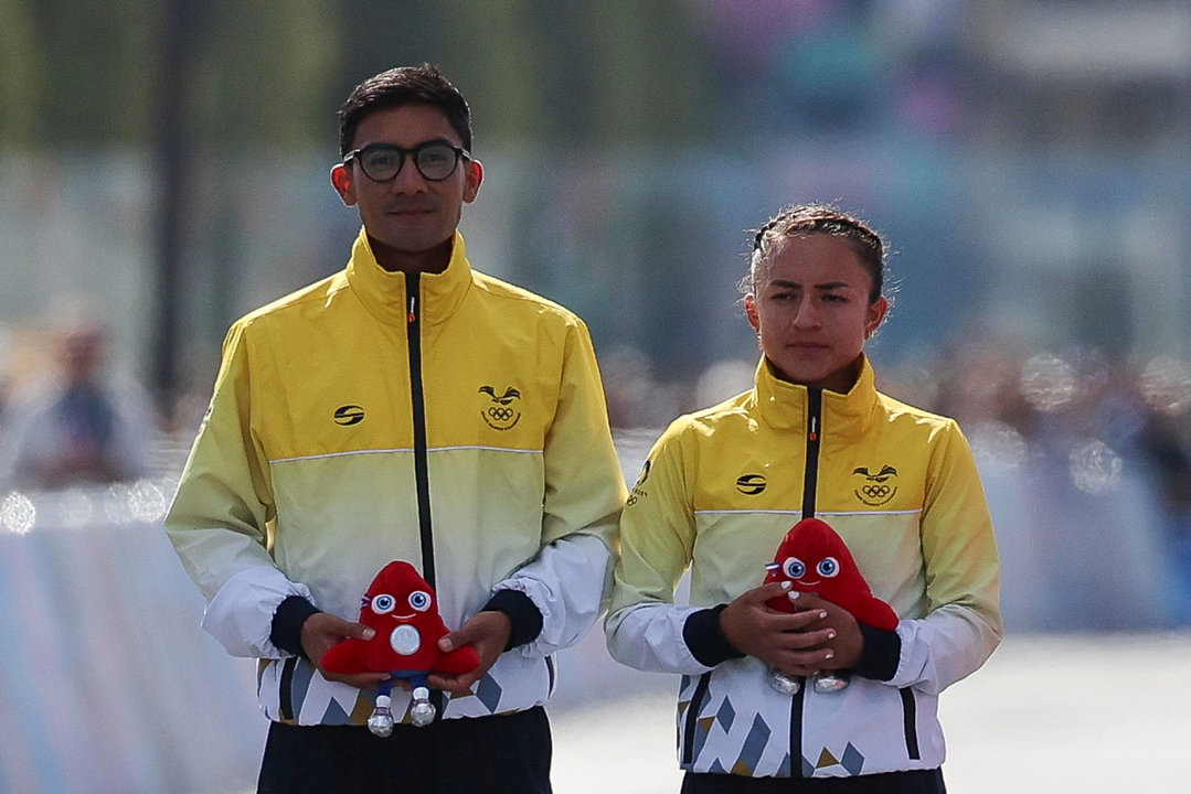 Los atletas ecuatorianos Brian Daniel Pintado (i) y Glenda Morejón (2i) posan tras ganar la plata en la prueba de maratón mixto de marcha. EFE/ Miguel Gutiérrez