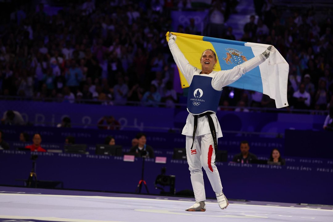 La húngara Viviana Marton, que se proclamó campeona olímpica en taekwondo, en la categoría de -67 kilos, sorprendió al término de su combate con la croata Aleksandar Perisic en la final y sobre el tapiz, sacó la bandera de Canarias, donde ha vivido su infancia. EFE/EPA/DIVYAKANT SOLANKI