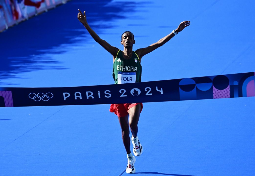 Tamirat Tola de Etiopía cruza primero la línea de meta del maratón masculino de París 2024, con un tiempo de 2h06:26, nuevo récord olímpico. EFE/EPA/ANNA SZILAGYI