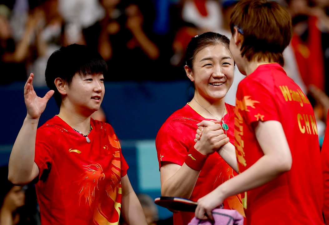 La  china Wang Manyu (d) celebra con sus compañeras Sun Yingsha (I) y Cheng Meng after la victoria ante Japón en la final en el South Paris Arena in Paris, Francia. EFE/EPA/YOAN VALAT