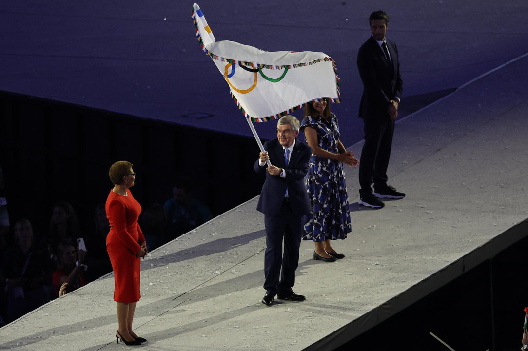 La alcaldesa de Los Angeles, Karen Bass (i), recibe la bandera olímpica de manos del presidente del COI, Thomas Bach (c), durante la ceremonia de clausura de los Juegos Olímpicos de París 2024 celebrada en el Estadio de Francia en Saint-Denis. EFE/ Miguel Gutiérrez