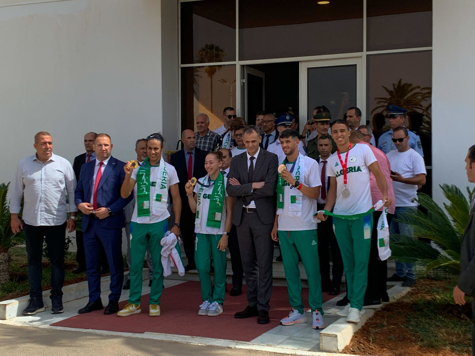 (izda a dcha) Imane Khelif, medalla de oro en boxeo femenino -66 kilogramos; Kaylia Nemour, oro en barras asimétricas y Djamel Sjati, medallista de bronce olímpico en los 800 metros posan durante una recepción con el ministro argelino de Deportes, Abderrahmane Hammad, durante una  recepción en el aeropuerto de Argel de los medallistas olímpicos. EFE/ Laura Fernández Palomo