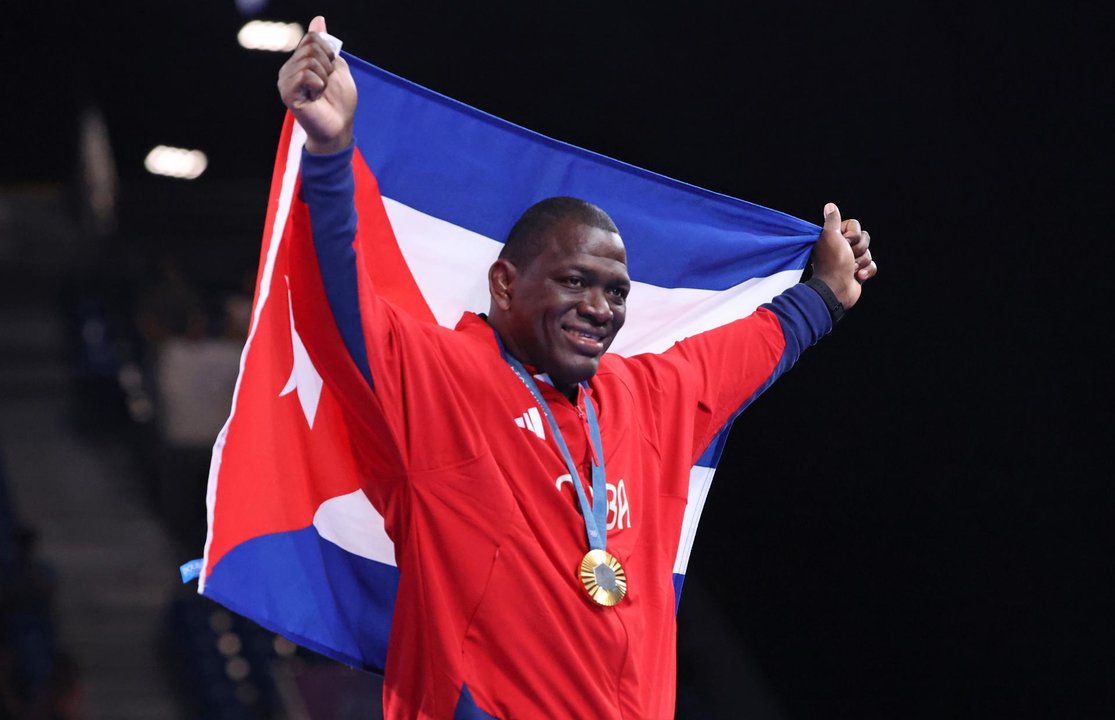 El medallista olímpico cubano Mijain Lopez celebra con la bandera de su país la medalla de oro obtenida en París 2024. EFE/EPA/YAHYA ARHAB